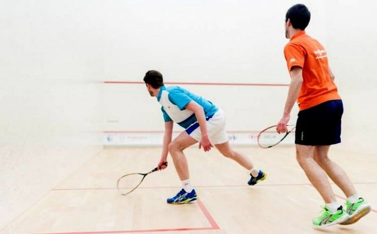 dwóch młodych mężczyzn rozgrywa mecz squasha