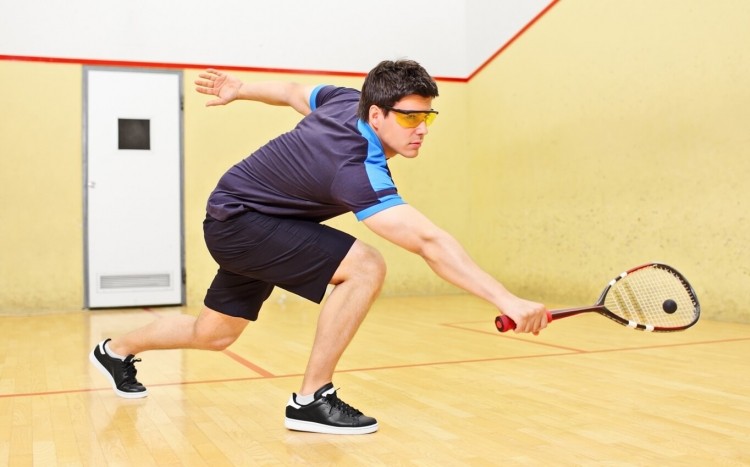 mężczyzna gra w squasha na korcie