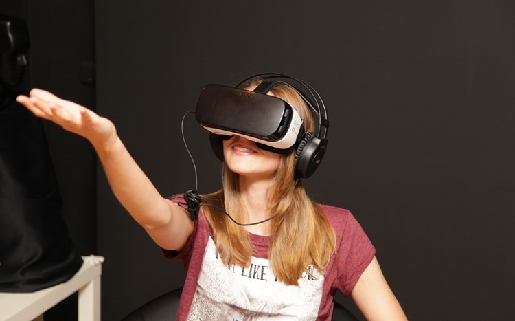 Dziewczyna w goglach VR z wyciągniętą ręką