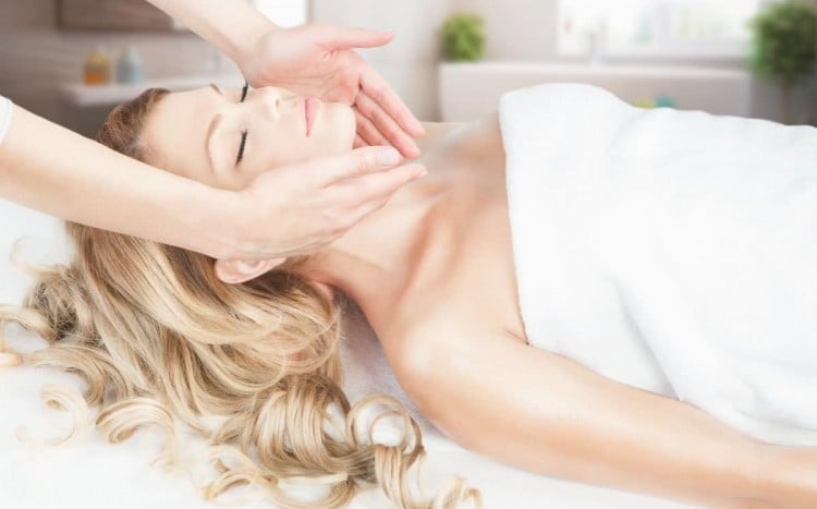 zrelaksowana kobieta podczas masażu twarzy